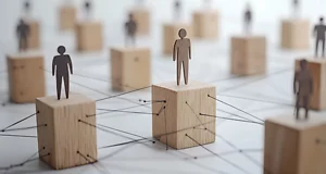 “Wooden blocks with stick-figure silhouettes of people standing on top, connected by black string to represent a social or professional network.