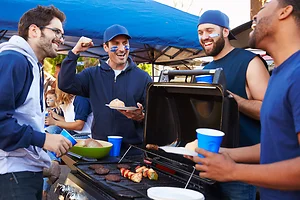 Group Of Male Sports Fans Tailgating In Stadium Car Park